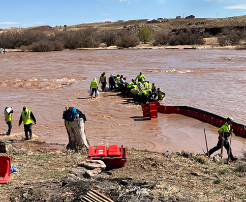 Un equipo despliega barreras modulares en una zona inundada.